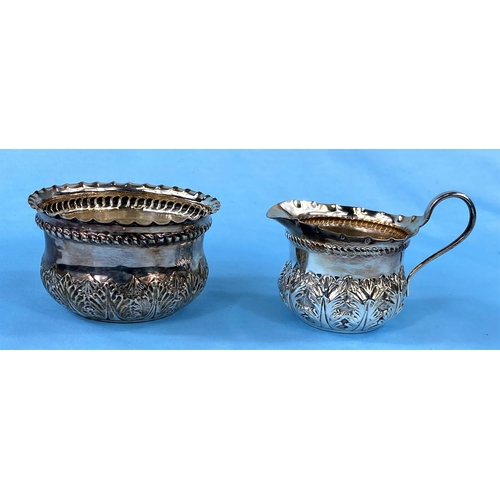 302 - A hallmarked silver sugar & cream set with extensive embossed decoration, London 1889, 3.5oz