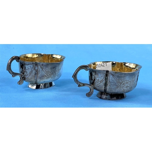 305A - An 18th century pair of Russian silver oval single handled white metal drinking vassals bearing mark... 