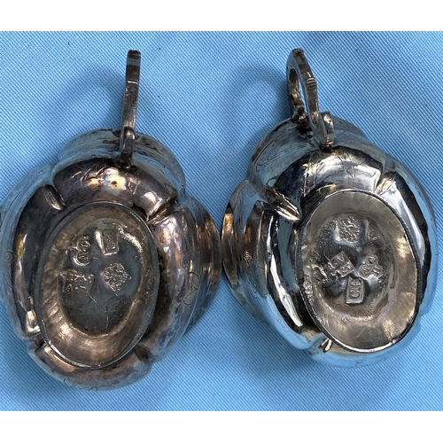 305A - An 18th century pair of Russian silver oval single handled white metal drinking vassals bearing mark... 