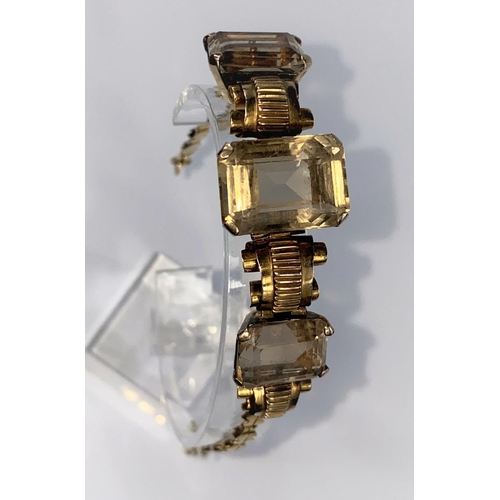 370 - A continental yellow metal bracelet set with 3 rectangular Smokey citrine stones tested 14ct, trigge... 