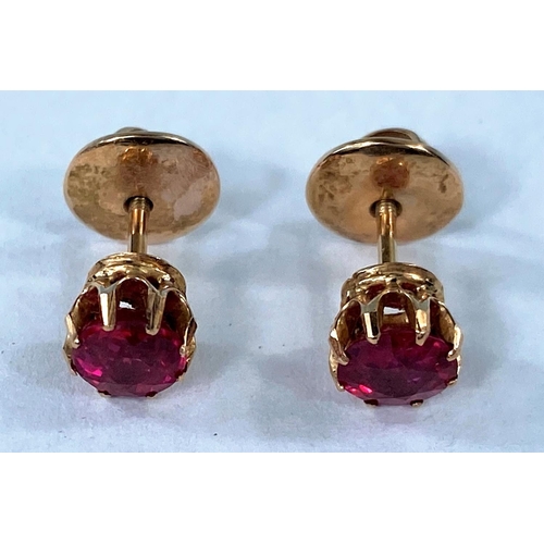 419 - A pair of yellow metal screw pin stud earrings set with rubies (unmarked, test as circa 18ct) 2.4gm