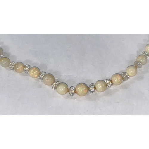 323 - A graduated opal bead necklace, 53 beads from 4mm - 9mm, interspersed with small crystal beads, leng... 