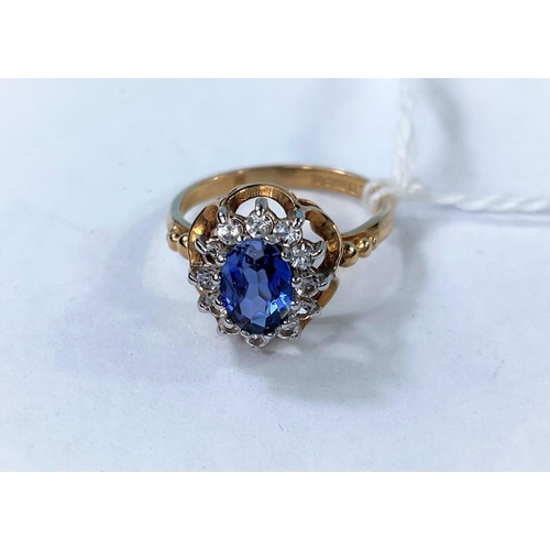 335 - A 9 carat hallmarked gold dress ring set oval sapphire coloured stone, surrounded by clear stones, 2... 