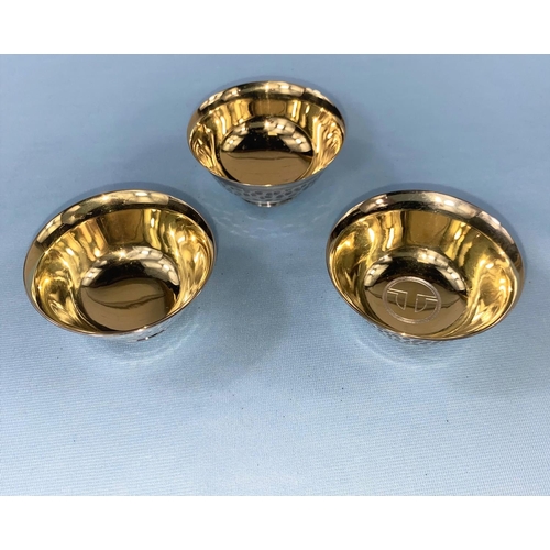 404 - Three Japanese white metal sake cups with hammered details to the outside and a gilded interior, all... 