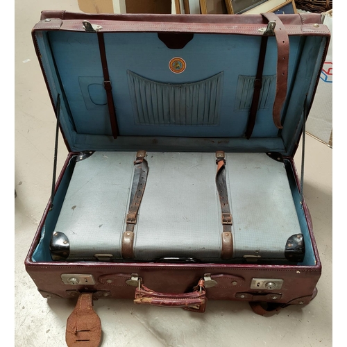31 - A large strapped leather suitcase; a compressed card suitcase