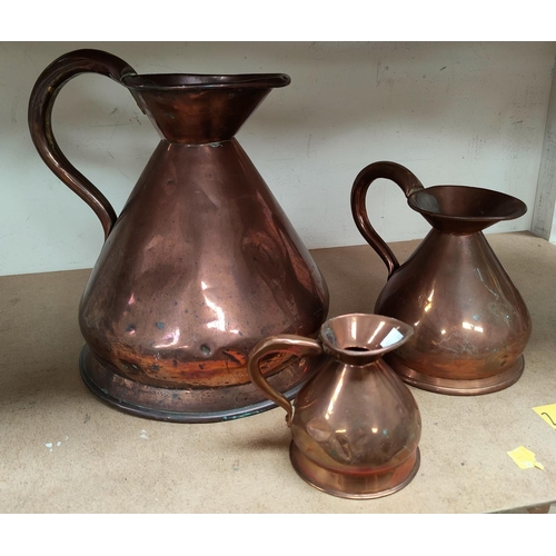 50B - A 19th century matched set of three graduating copper measuring jugs, the smaller of the three stamp... 