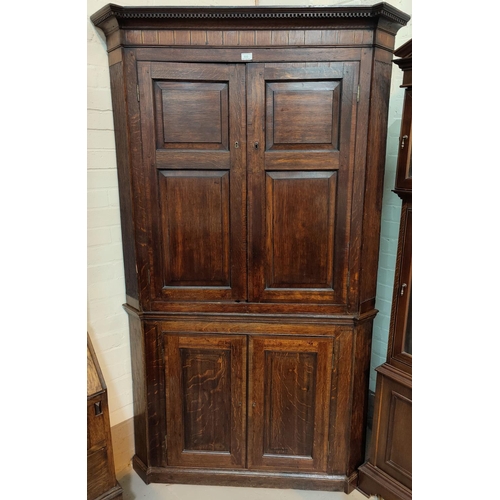 532 - A Georgian oak full height corner cupboard with dentil cornice, inlaid frieze, reeded side columns, ... 