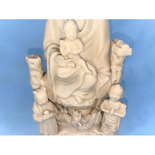 175 - A Chinese blanc de chine figure of Guanyin and Chi, seated above a dragon with acolytes to either si... 
