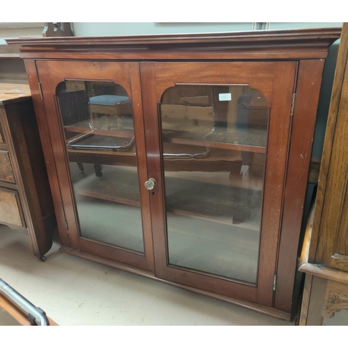 510 - A 1920's mahogany display cabinet enclosed by 2 doors on ball and claw feet (one glass pain cracked)