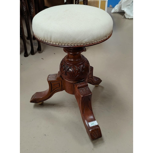 543 - A Victorian carved walnut piano stool with circular revolving top, on triple splay feet