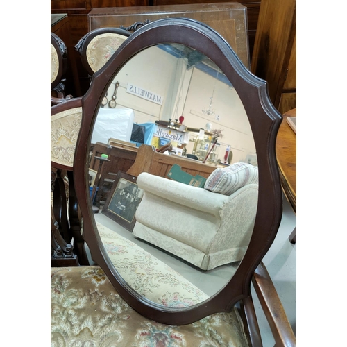 595 - A mid century teak wall mirror in rounded rectangular elongated frame; an oval mirror in  mahogany f... 