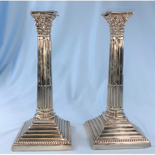 436 - A hallmarked silver pair of candlesticks with Corinthian columns on weighted square stepped bases, L... 