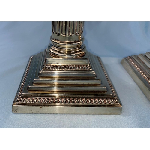 436 - A hallmarked silver pair of candlesticks with Corinthian columns on weighted square stepped bases, L... 