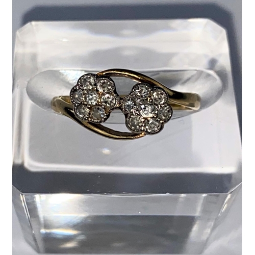 420 - A yellow metal crossover dress ring set with twin 7 stone diamond flowerhead clusters, stamped 18ct ... 