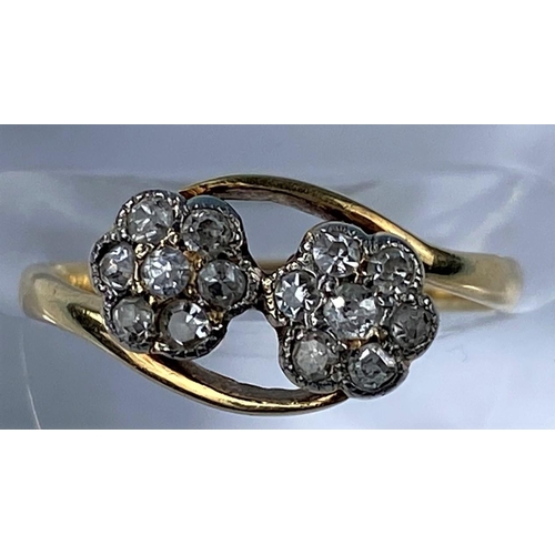 420 - A yellow metal crossover dress ring set with twin 7 stone diamond flowerhead clusters, stamped 18ct ... 