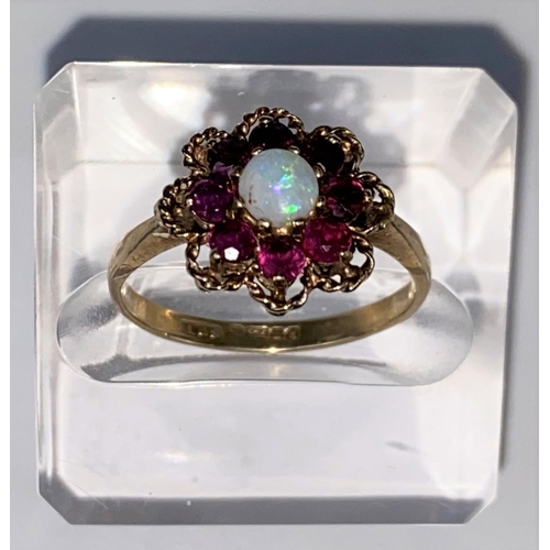 440 - A vintage opal & almondine garnet yellow gold cluster ring, comprising of a central round opal surro... 