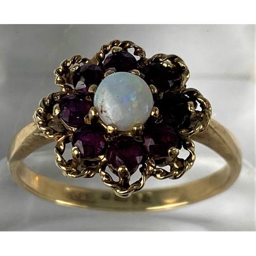 440 - A vintage opal & almondine garnet yellow gold cluster ring, comprising of a central round opal surro... 