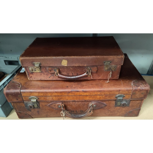 36 - A vintage leather travel suitcase in tan colour, monogrammed H.L.B. and a similar smaller one.