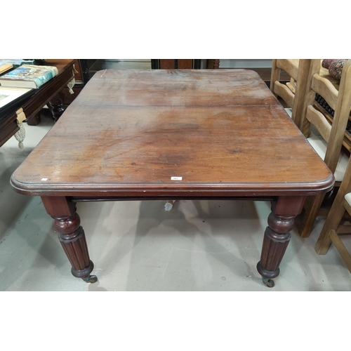 561 - A Victorian mahogany dining table with rounded rectangular wind out top and 2 spare leaves, on turne... 