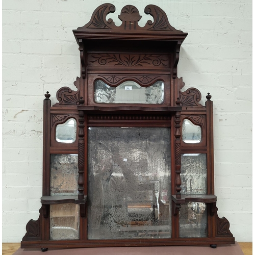 584 - An Edwardian overmantel mirror in carved walnut frame (mirror a.f.)