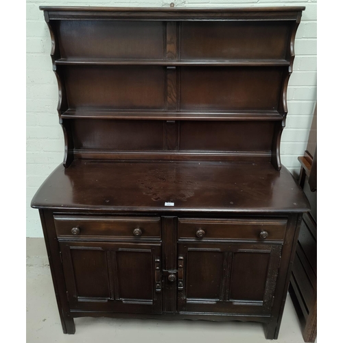 606 - An Ercol dark oak Welsh dresser with 2 height delft rack over 2 cupboards and 2 drawers