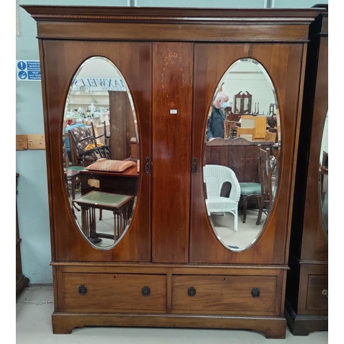 614 - An Edwardian inlaid mahogany double wardrobe in the Sheraton style,  part fitted interior with slidi... 