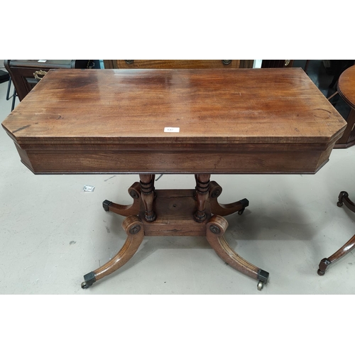 647 - An early 19th century mahogany card table with canted foldover top, on 4 turned columns, splay feet ... 