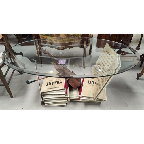 665 - A coffee table with oval glass top and 'violin & music' base
Base is made from composite resin, it i... 