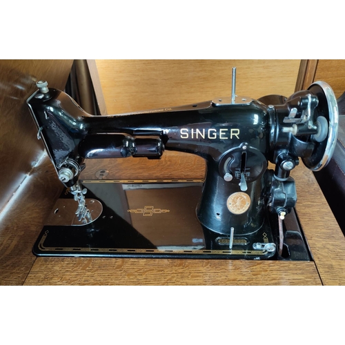 672 - A 1930's Singer treadle sewing machine in veneered oak cabinet