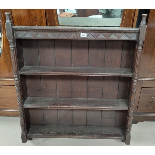 695 - An oak Arts & Crafts wall hanging bookcase with carved turned side columns, carved rose crest top ce... 