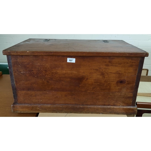 697 - A stained pine chest with hinged top.