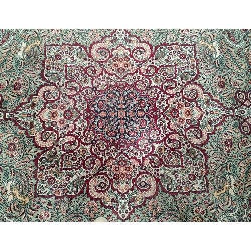 713 - An impressive large Middle Eastern style carpet, fawn ground with geometric decoration and animals e... 