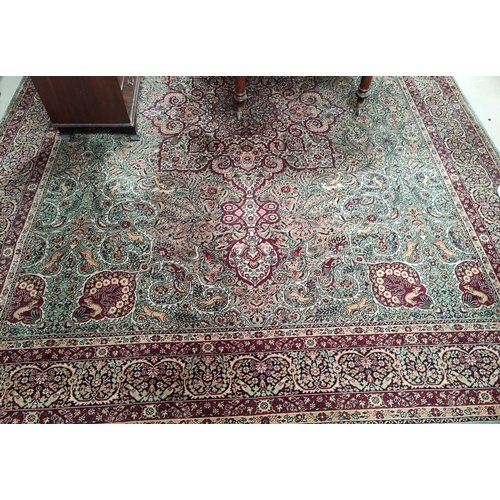 713 - An impressive large Middle Eastern style carpet, fawn ground with geometric decoration and animals e... 