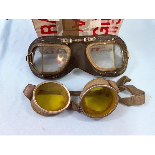 224 - A pair of aluminum framed goggles with yellow tint lenses, another pair, a trench art lighter etc