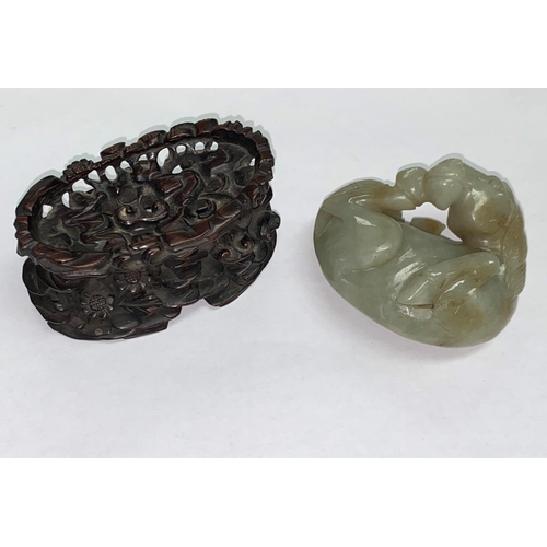 336 - A Chinese jade coloured hardstone carving of a foal curled up on associated intricately carved woode... 