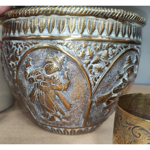 125 - An Indian brass jardinière with paneled decoration in relief of Hindu gods. H: 16cm, Diameter: 20cm;... 