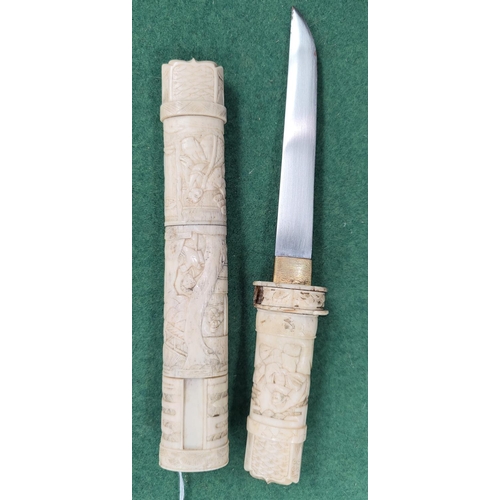 151 - A Japanese dagger in carved sectional case with figured decoration