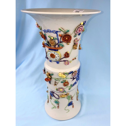 334 - A large Chinese beaker vase with areas of relief and raised decoration on a white background having ... 