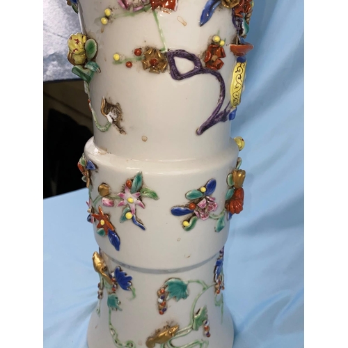 334 - A large Chinese beaker vase with areas of relief and raised decoration on a white background having ... 