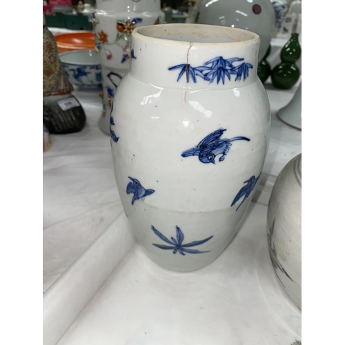 335 - A Chinese blue and white vase decorated with plants and birds (firing crack running from the rim), a... 