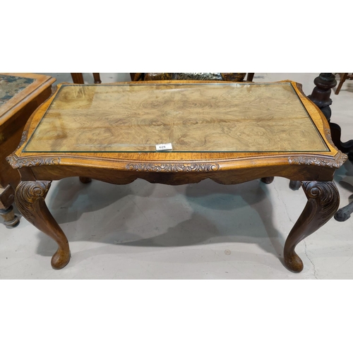 628 - A reproduction figured walnut coffee table on carved cabriole legs