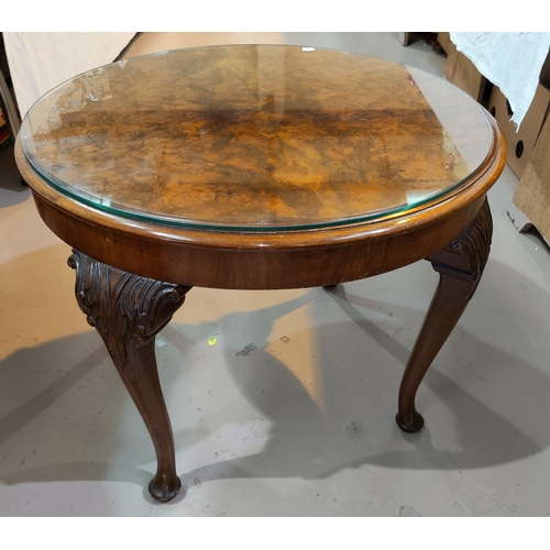 632 - A walnut coffee table with circular top on carved cabriole legs