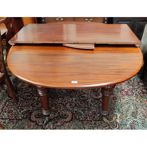 640 - A Victorian dining table with extending oval top and spare leaf, on turned legs and castors, extende... 