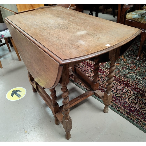 718 - A 1930's oak table with oval dropleaf top on barley twist legs, 119cm open, 90cm max width; 4 simila... 