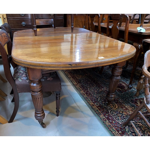 617 - An early 19th century mahogany dining table with extending 'D' end top, on turned, fluted legs and c... 