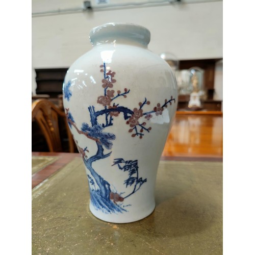 333 - A Chinese blue and white inverted baluster vase depicting trees on landscape with red highlights bea... 