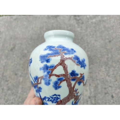 333 - A Chinese blue and white inverted baluster vase depicting trees on landscape with red highlights bea... 