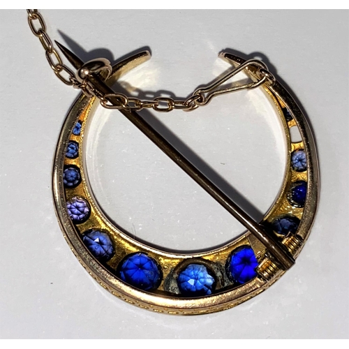 512 - An early 20th century 9ct gold crescent brooch sapphire and other stones (replacements) interspersed... 
