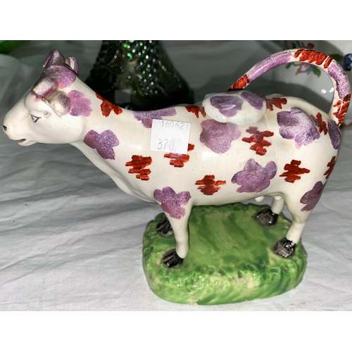 370 - A 19th century Staffordshire cow creamer with pink lustre splashwork decoration, 18 cm; a similar sp... 