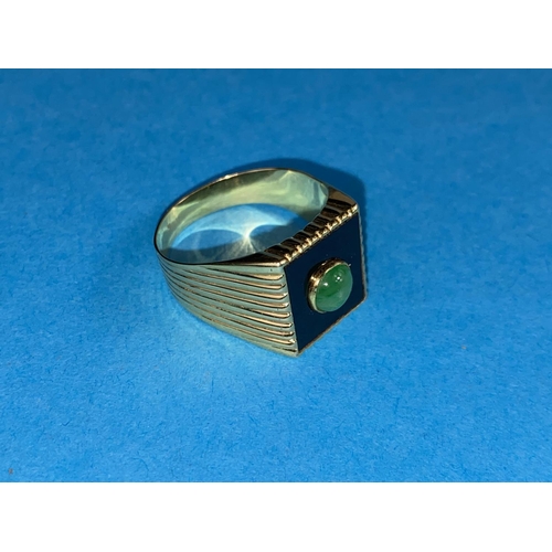 541 - A yellow metal gent's signet ring set with square jet coloured base with central jade coloured domed... 